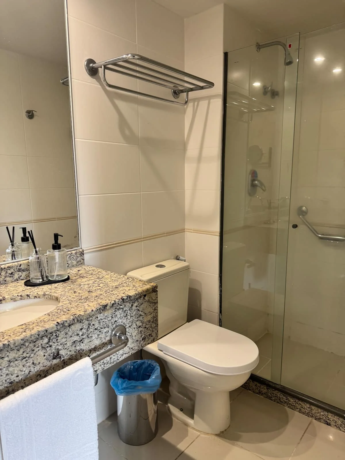 Banheiro com box de vidro e bancada de granito