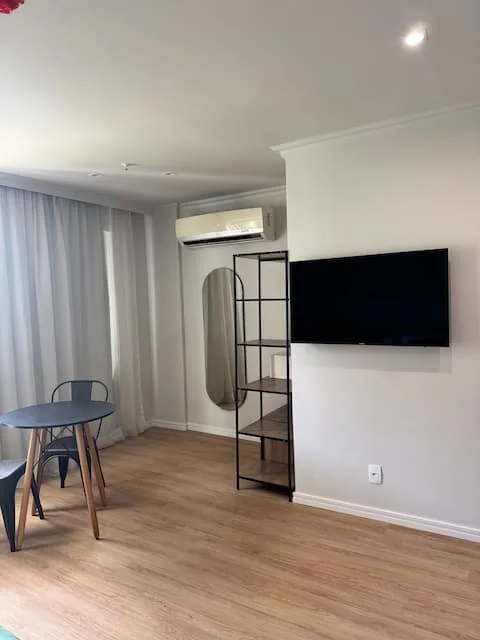 Sala com TV, mesa e ar-condicionado