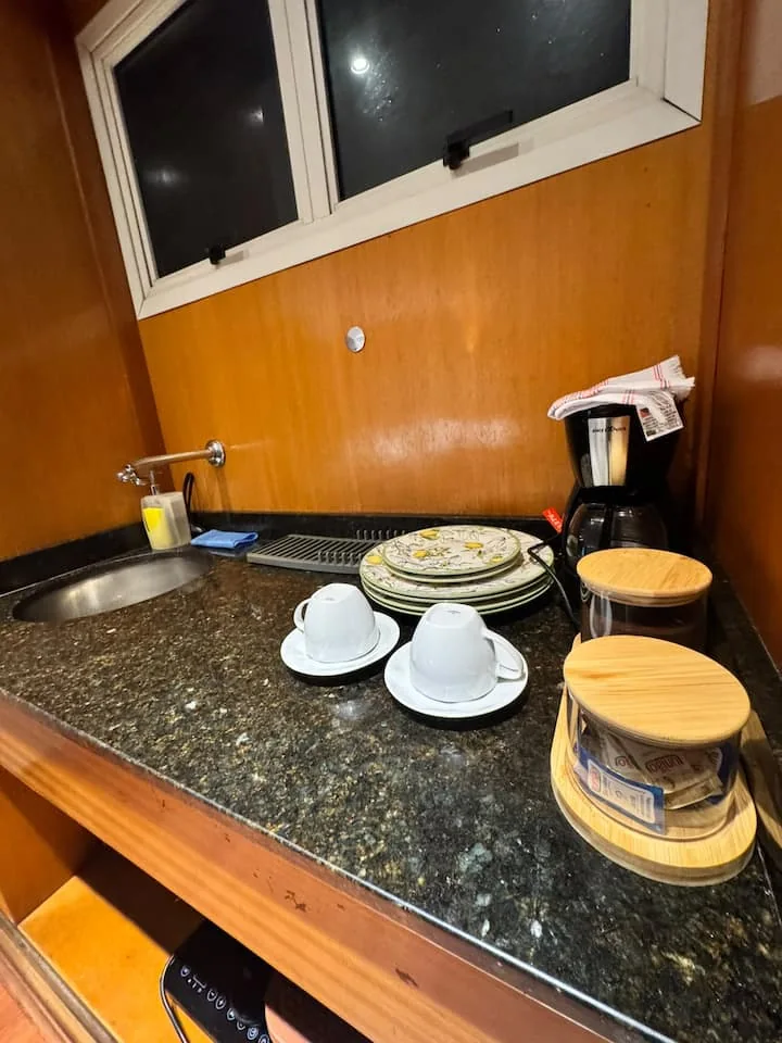 Kitchenette com cafeteira, xícaras e louças