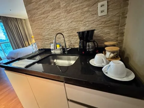 Kitchenette com pia, cafeteira e xícaras