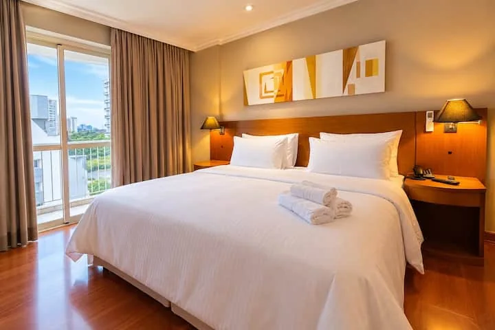Cama queen com roupa de cama branca