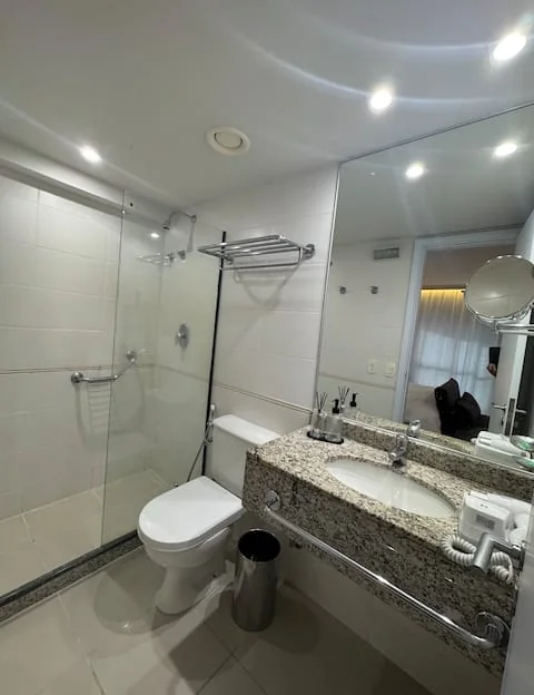 Banheiro com box de vidro e bancada de granito