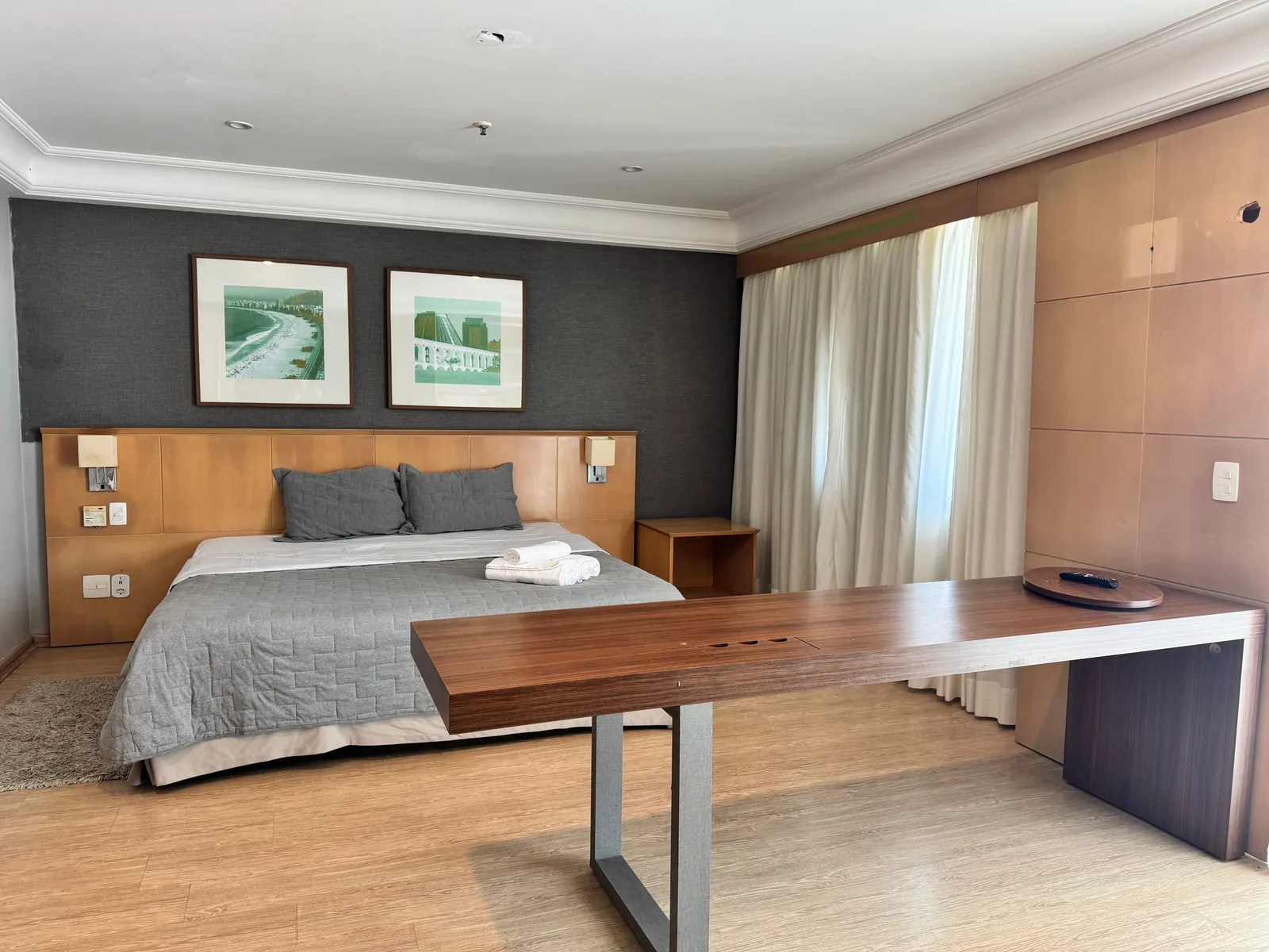 Cama king com mesa ampla e cortinas