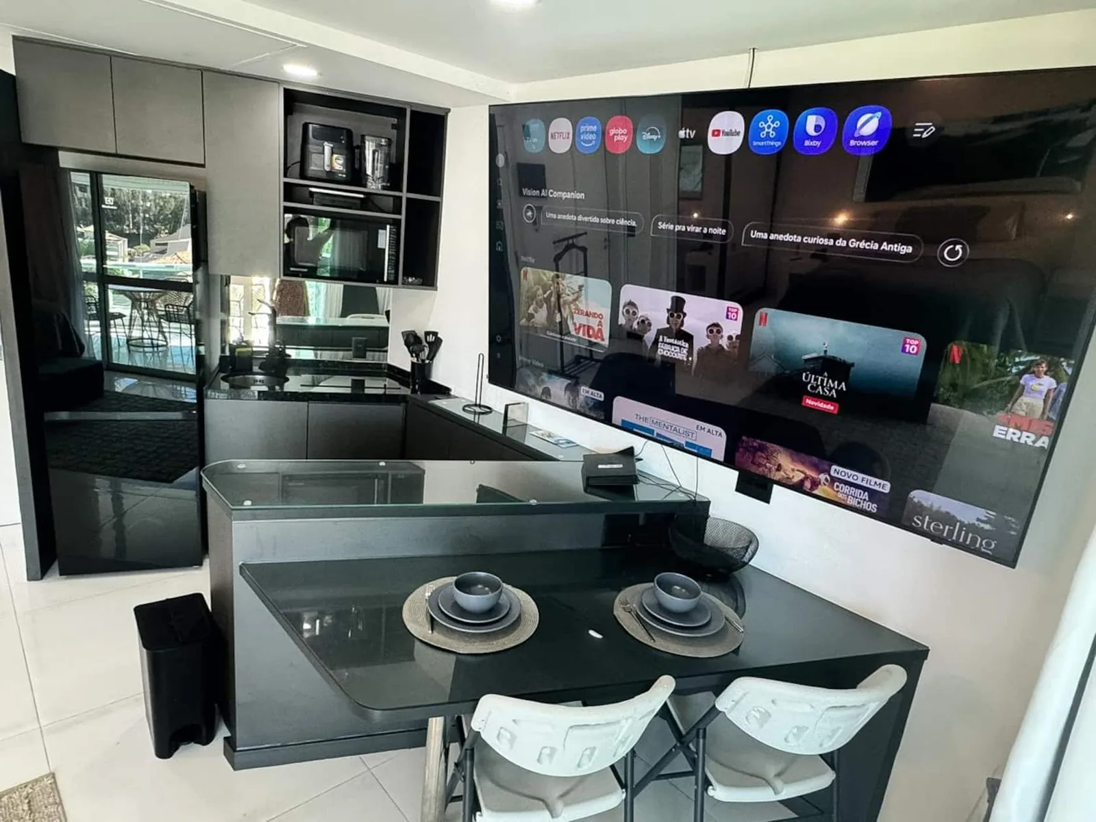 Cozinha americana com TV grande de parede